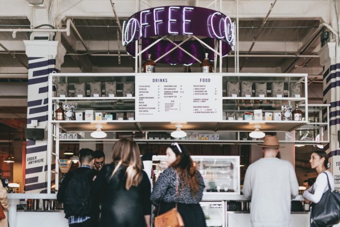 Consumers standing in line at a coffee shop